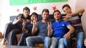 Del Grande davanti a una bandiera dell'insurrezione filo-atlantica in Siria